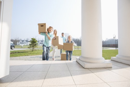 Mover wearing PPE while carrying furniture during a Harrow removal service